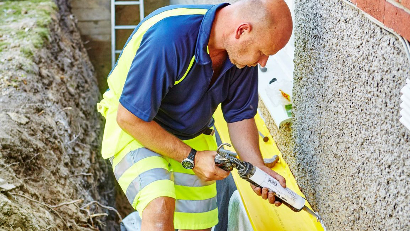 Man som insolerar hus.